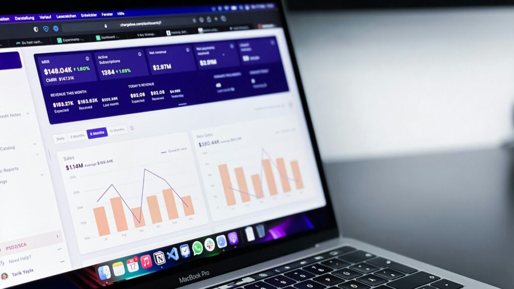 Laptop toont dashboard met grafieken en statistieken over omzet, sales en groei over meerdere maanden.