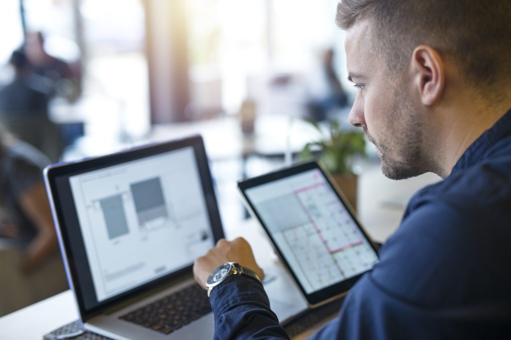 man werkt achter laptop